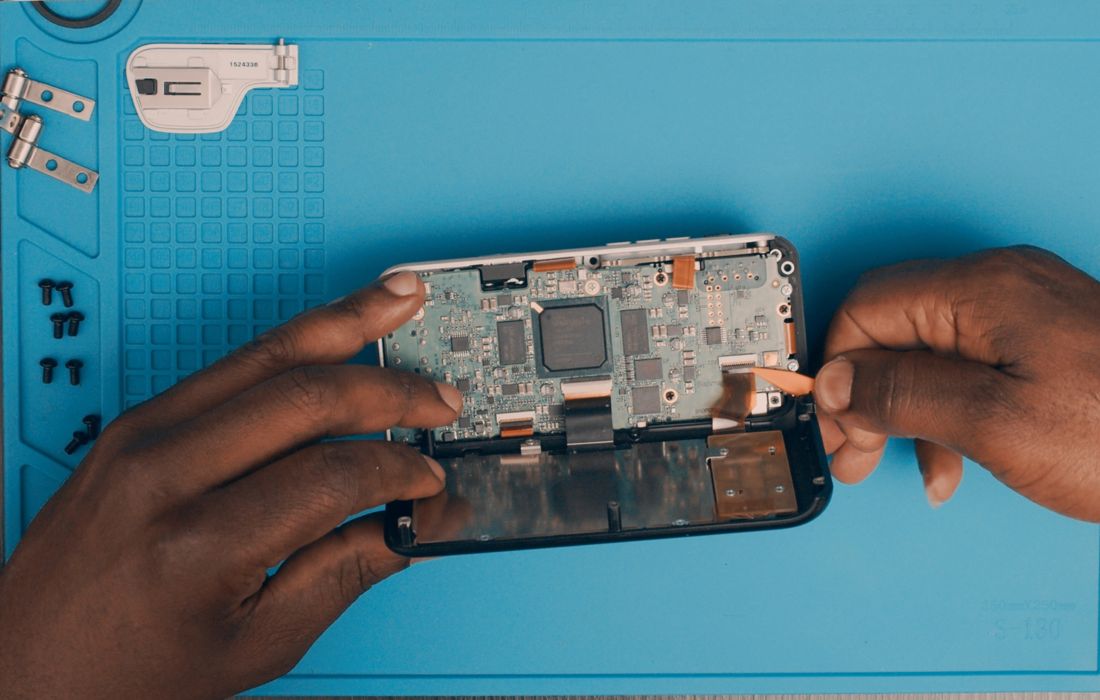 Lift the rear cover to expose the main board. Release or flip the FPC locking tabs and withdraw the cables.