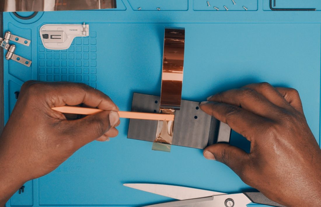 Lay the 20 mm BGA tape on the aluminum backplate. Press the tape into the sides with a spudger. Trim the excess.
