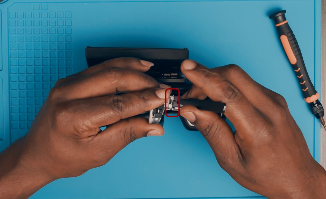 Center the battery door pin and use tweezers or a pin to reposition the spring so it sits against the body of the camera.